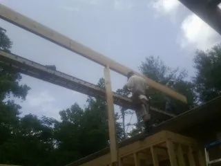 Carpenter setting a ridge beam over a new addition frame — Ice Dam Removal by Roofing Brothers in Greencastle