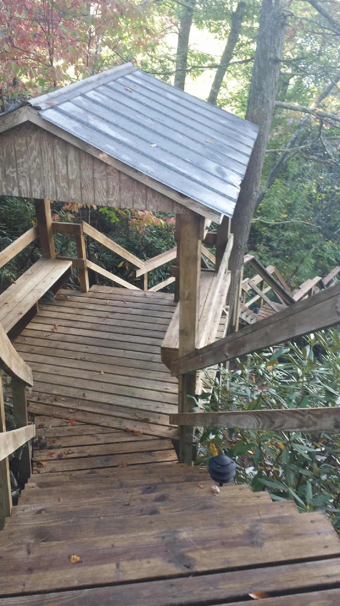 Metal roofed shelter over wooden steps on a wooded walkway — Skylight Repair & Installation work by our crew in Greencastle