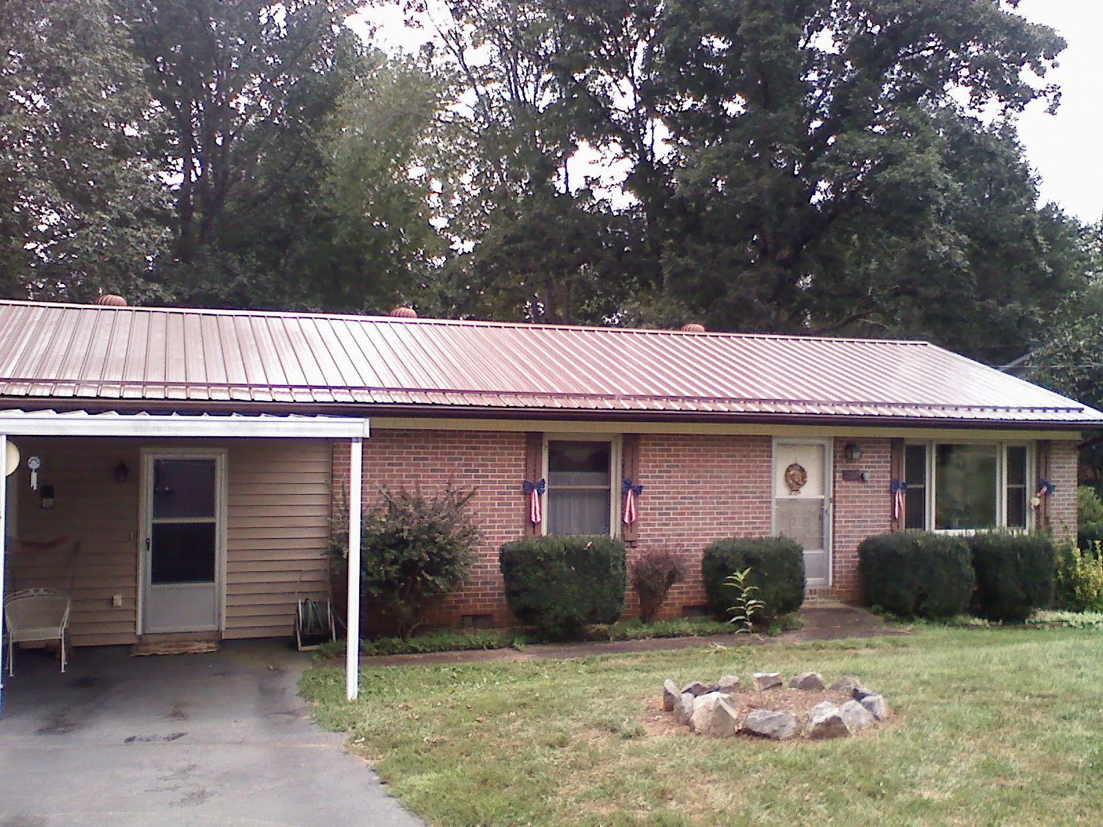 Bronze metal roof and carport on a brick ranch home — Roof Repair work by our crew in Greencastle