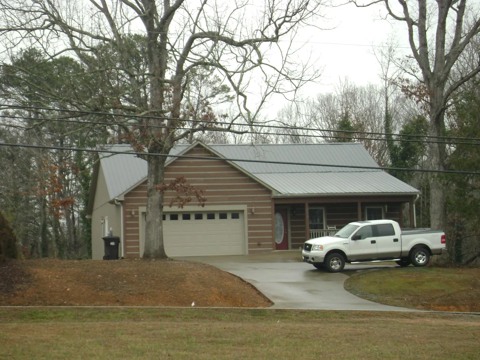 Gray metal roof on a log sided house with an attached two car garage in Greencastle